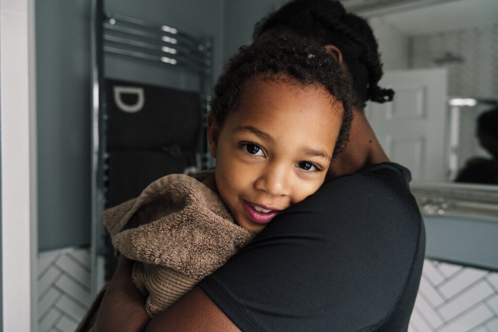 Child looking straight into the camera as the family documentary photographer is a part of your day. 
