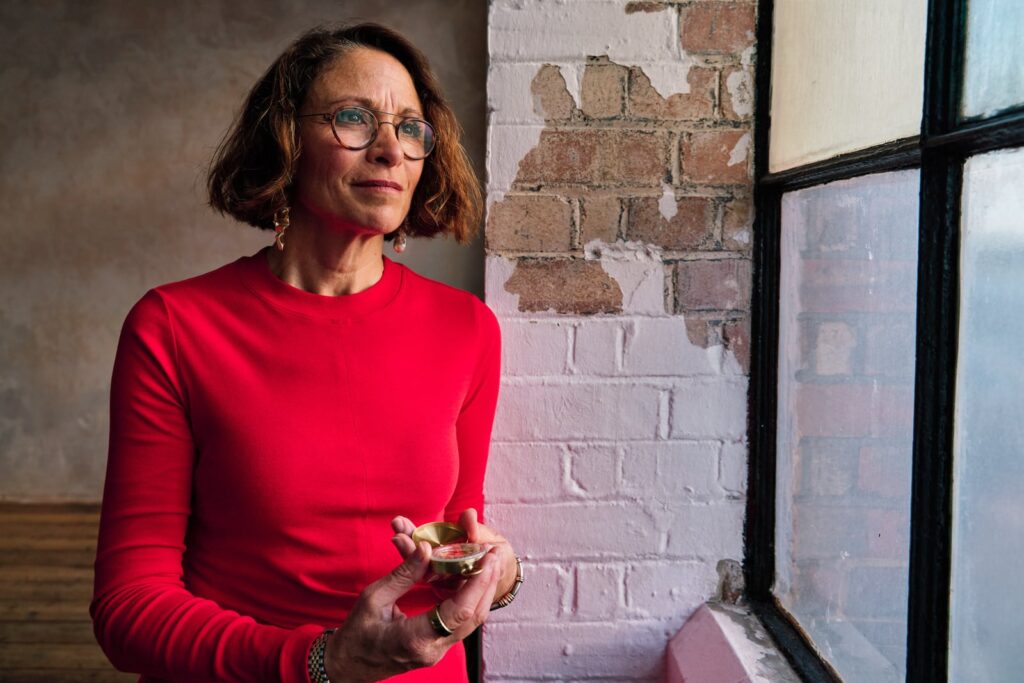 Portrait photography session at Sunset Studios in Peckham with motivational speaker looking out of warehouse style window. 