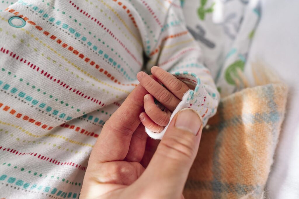 Holding my baby's hand to include it into my family photo to show I their mother was there too. 
