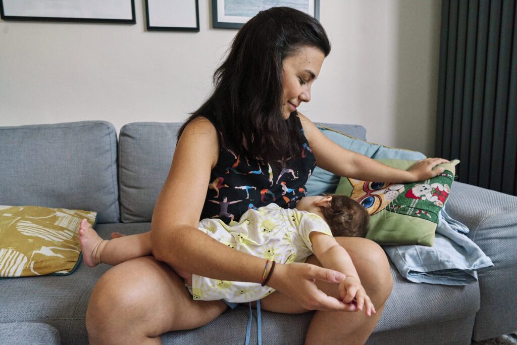 Mother breastfeeding her baby and showing that photos can show real moments that say I love you just as you are.