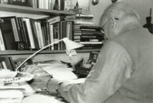 Grandfather sitting at his desk writing captured by his teen granddaughter photographer Saskia Albers.